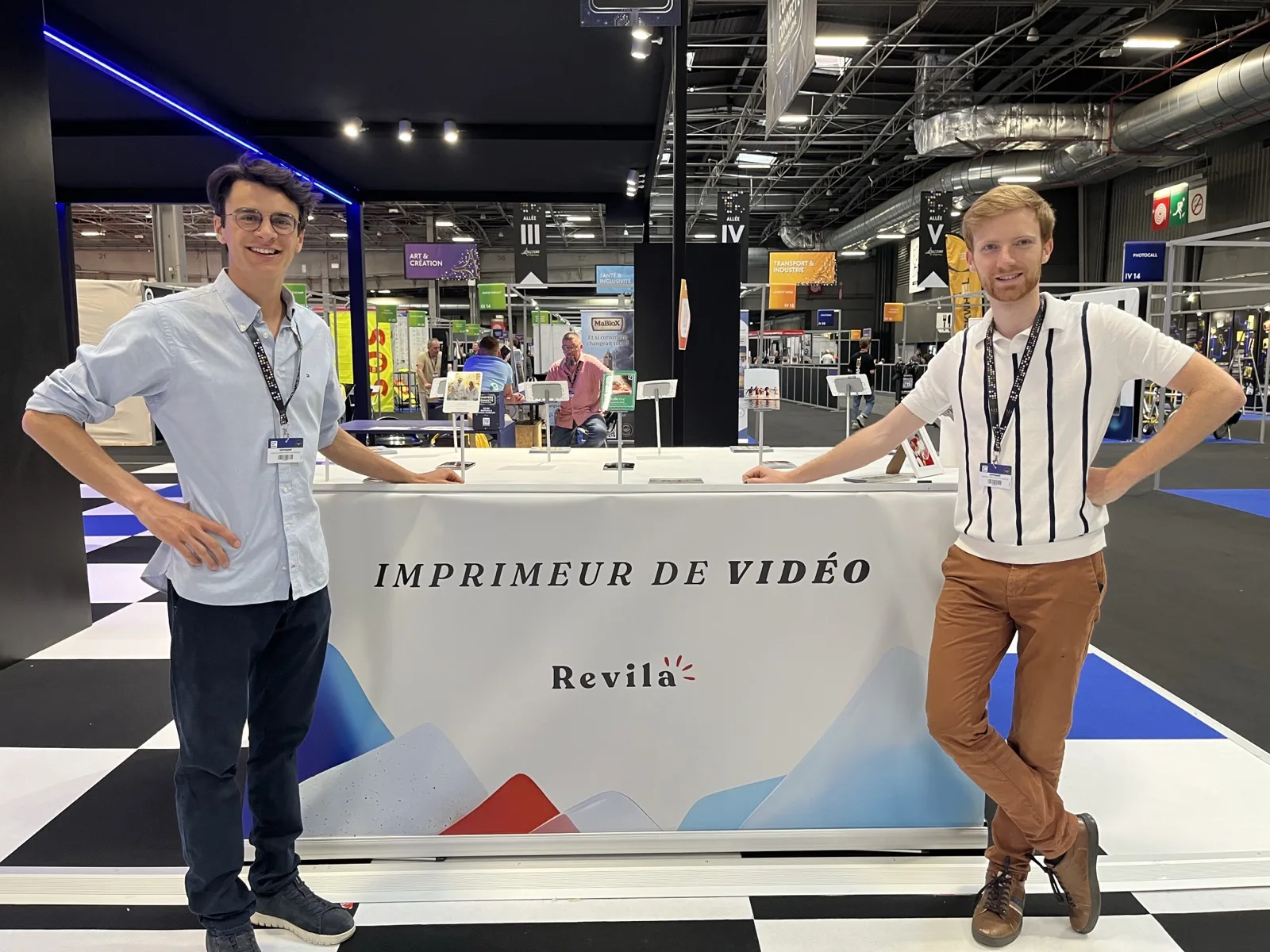 Henri Barraya et Simon Rosolen sur le stand Revila au Concours Lépine, devant l'enseigne Imprimeur de vidéo